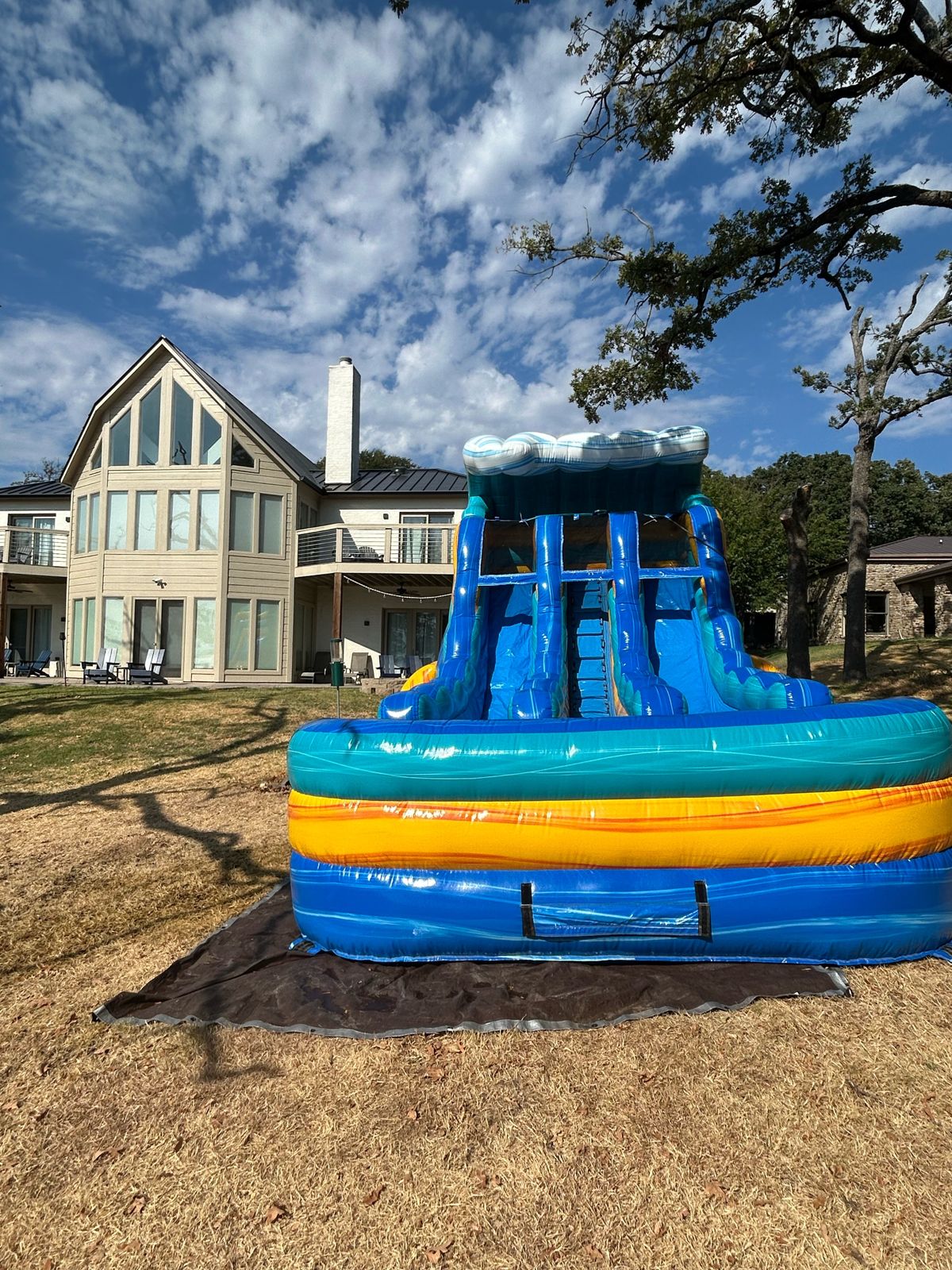 Bahamas Surf Wave water slide rental set up on grass at a lake house in Pottsboro, TX