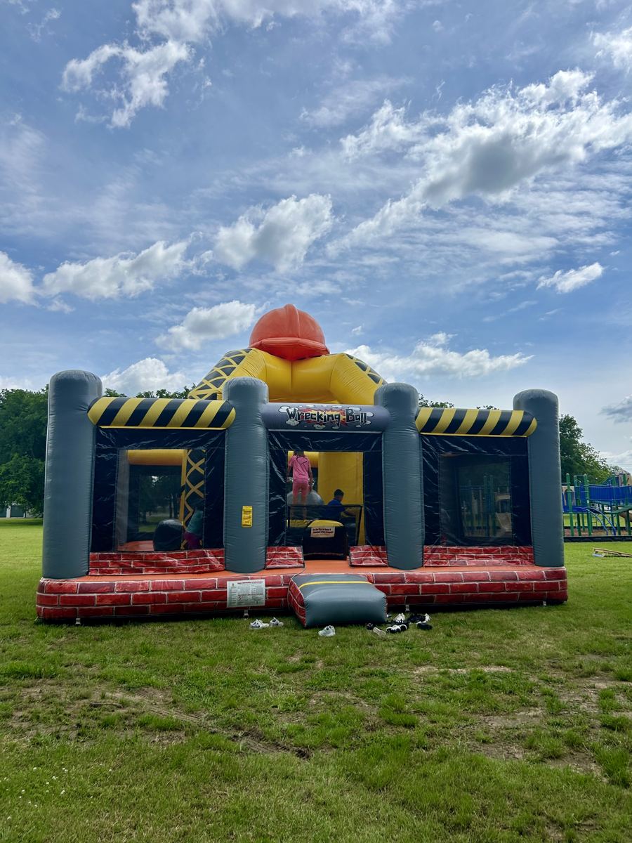 Construction-themed wrecking ball interactive inflatable set up on open grass at a park in Denison, TX