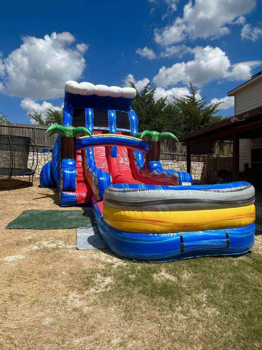 Tropical dual-lane inflatable water slide on a ground tarp in a Howe, TX backyard