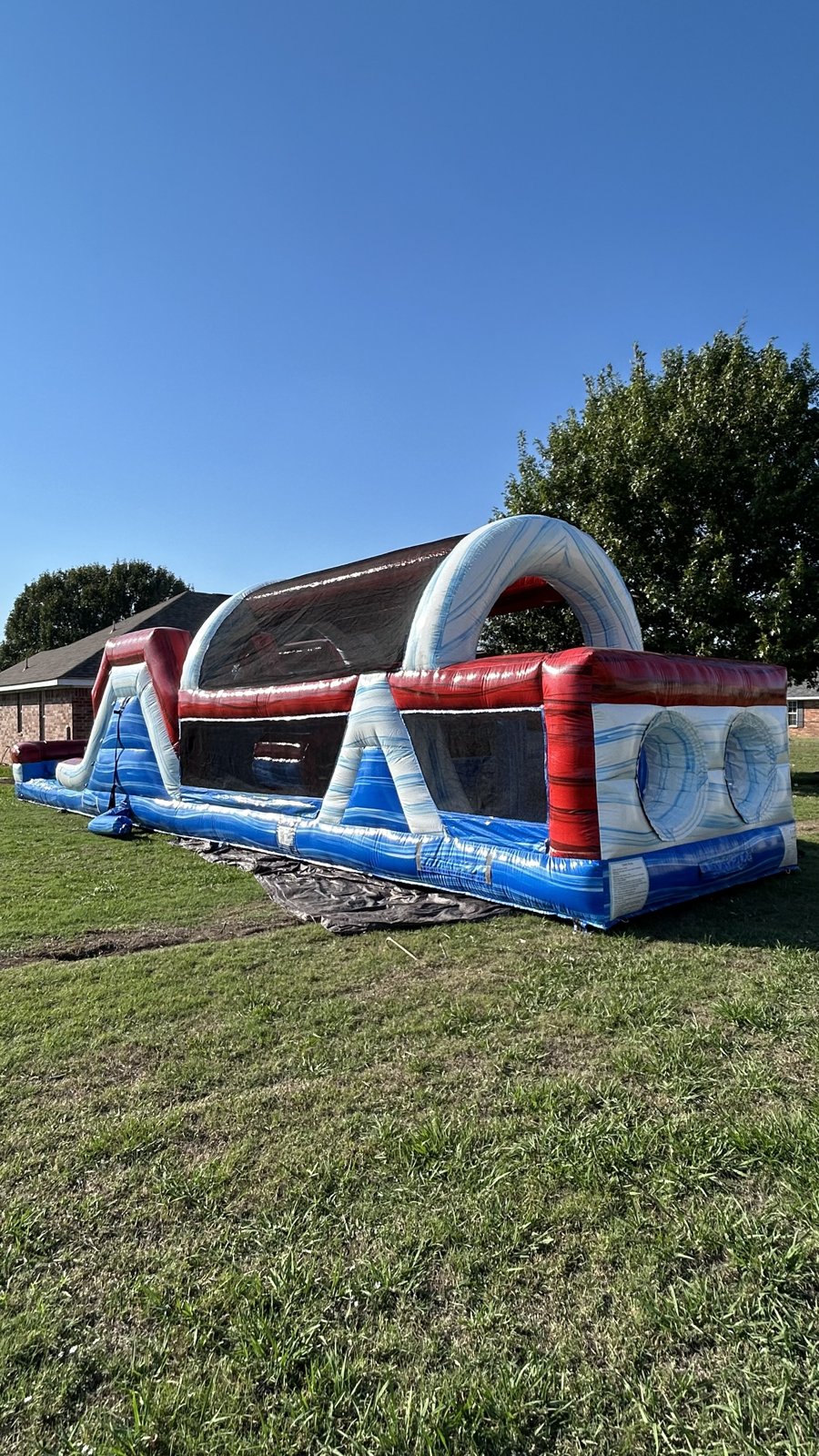 Marble-themed inflatable obstacle course set up on grass in Calera, OK